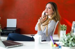 Portrait of beautiful young woman using her mobile phone in the office.